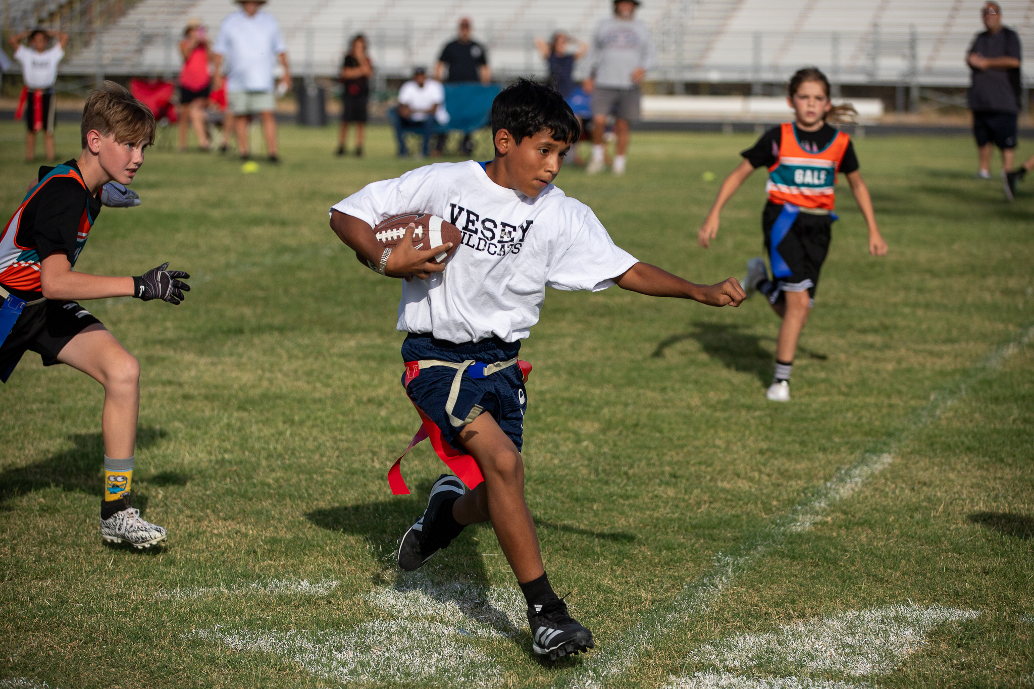 A Vesey player runs with the football under his arm away from his opponents