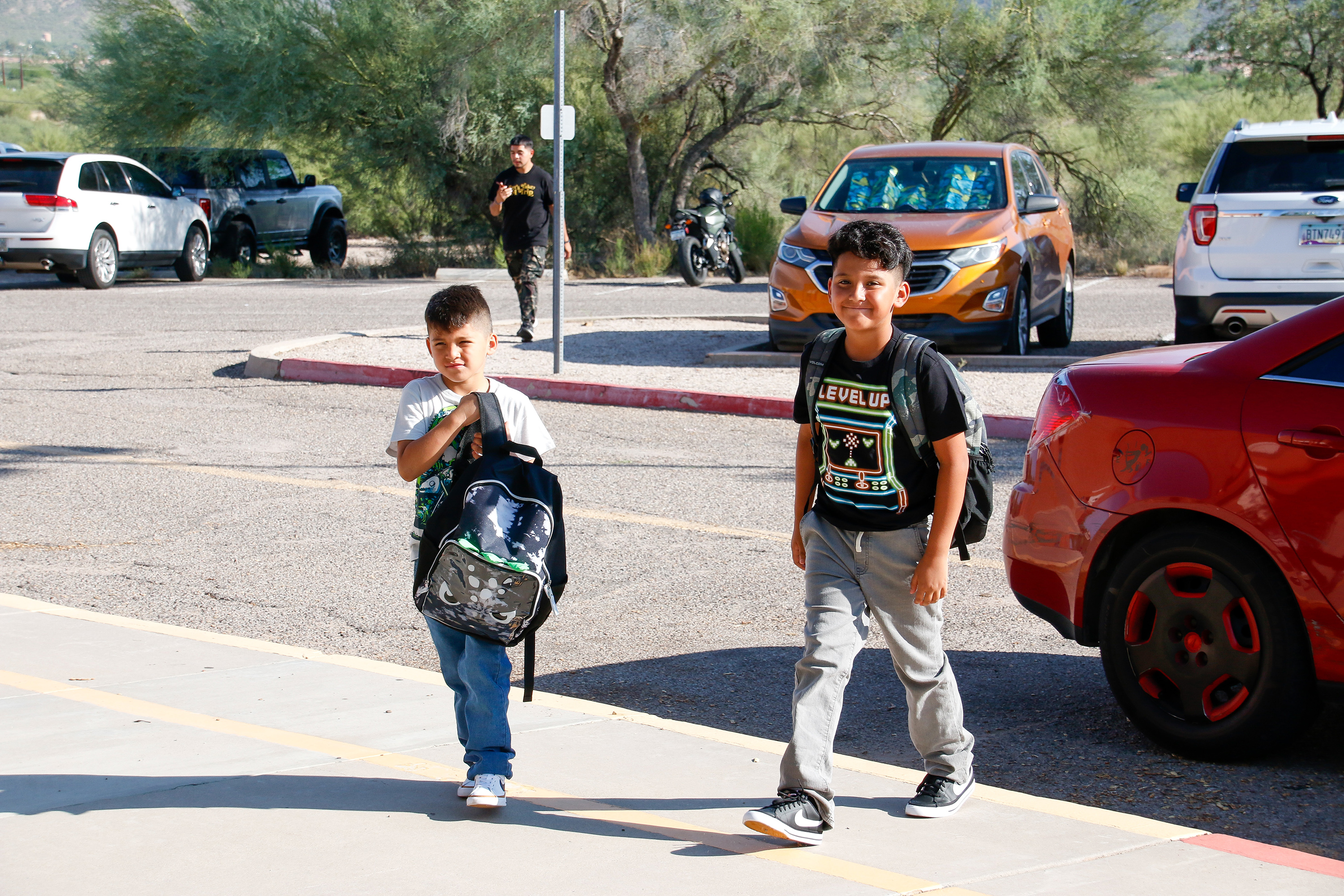 Two boys smile as they walk from the parking lot on the first day