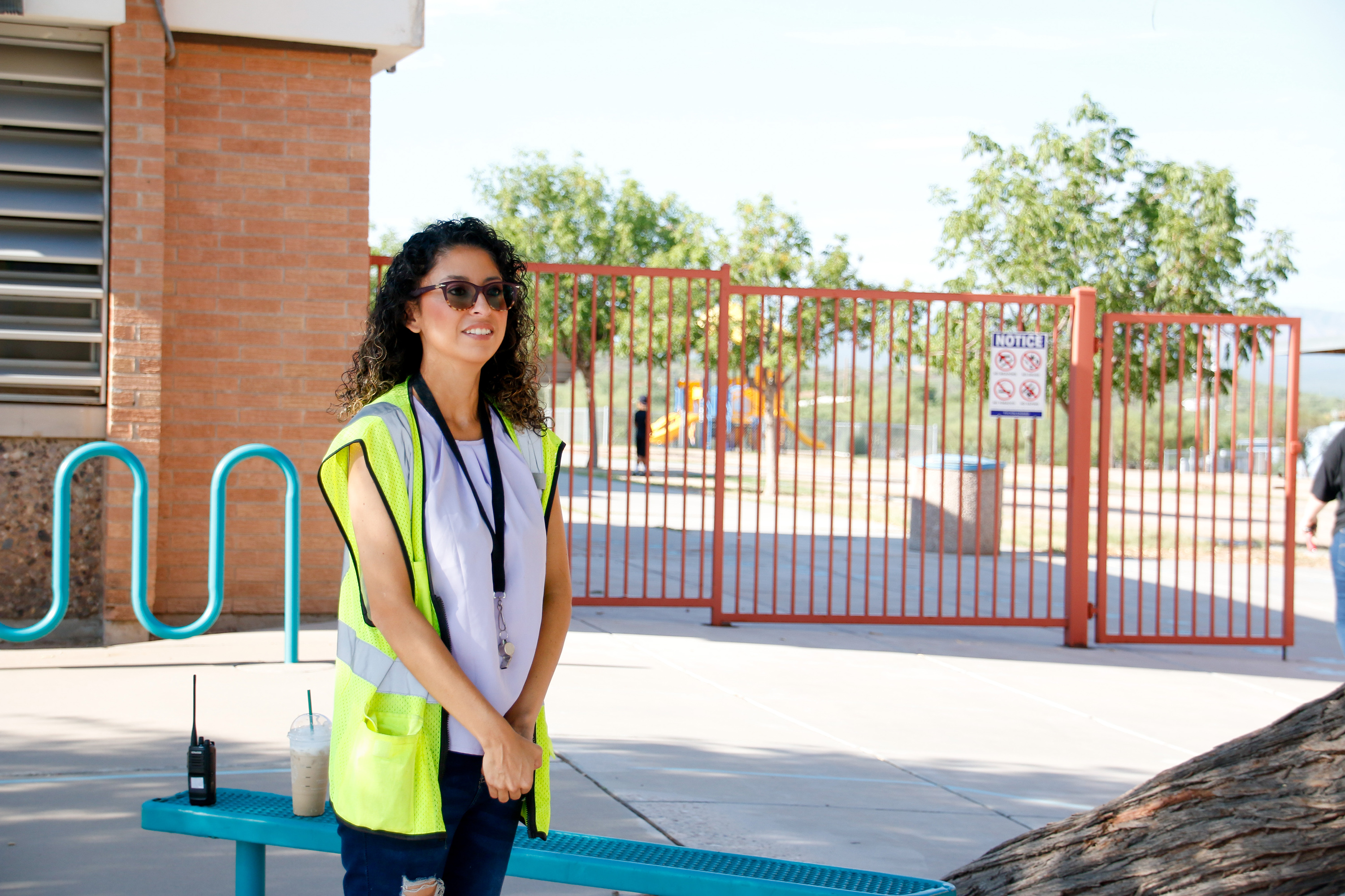 A school monitor smiles as she stands outside the school