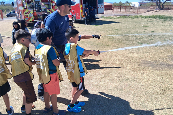Students spray fire truck hoses