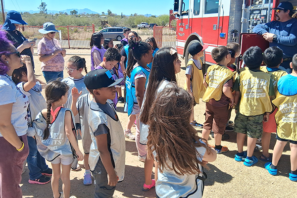 Students listen to a presentation by the fire department out in the school field